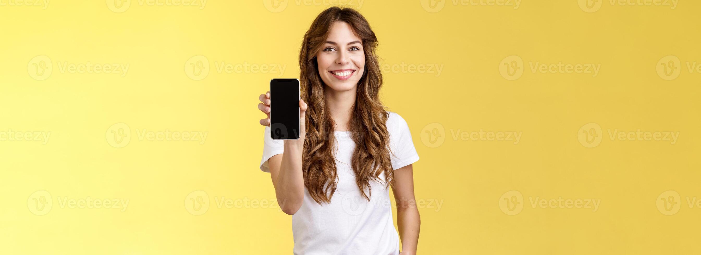 Questo App tutti voi bisogno. allegro amichevole estroverso elegante ragazza mostrando sua smartphone vuoto mobile Telefono Schermo telecamera introdurre sociale media pagina sorridente Contentissimo vantarsi banca account foto