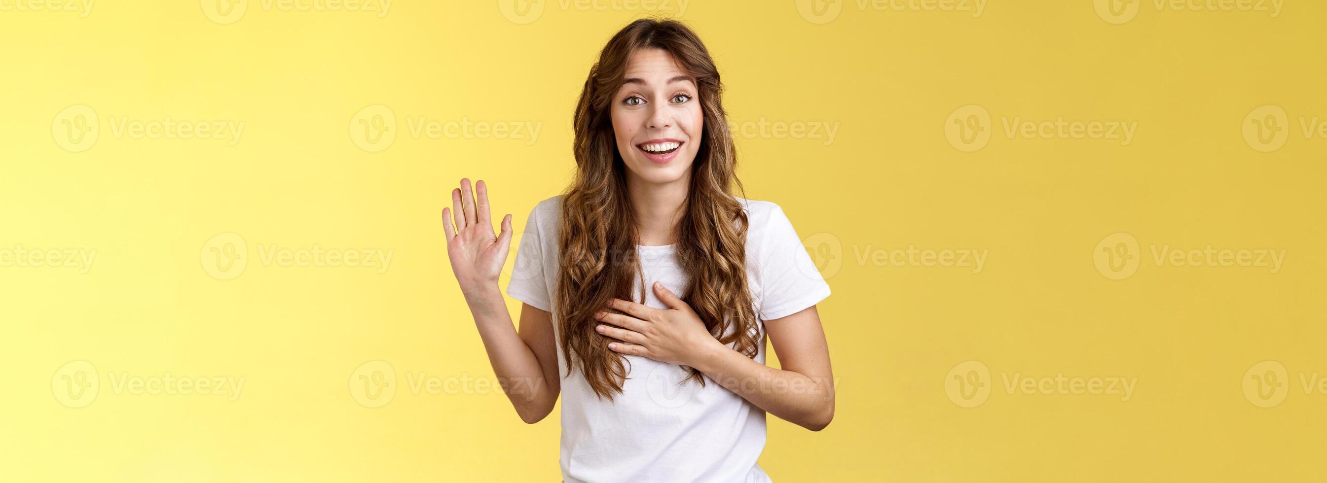 ragazza introdurre se stessa amichevole gioioso casuale conversazione sorridente a grandi linee hold mano cuore aumentare palma agitando giurare raccontare verità essere onesto ghignante rendere promettere giuramento In piedi giallo sfondo dire Ciao foto