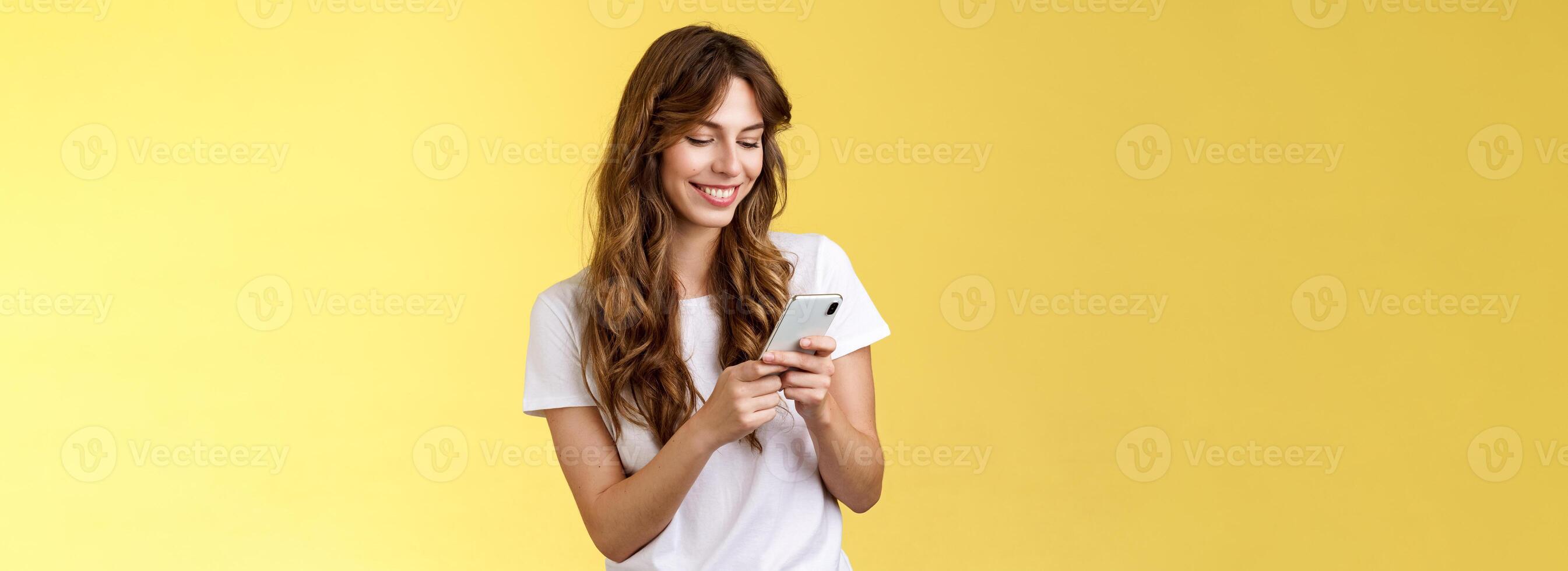 allegro bello fidanzata sms amico lieta carino Sorridi rubinetto smartphone schermo sorridente a grandi linee Guarda mobile Telefono Schermo teneramente scrittura inviare contemplare toccante foto giallo sfondo