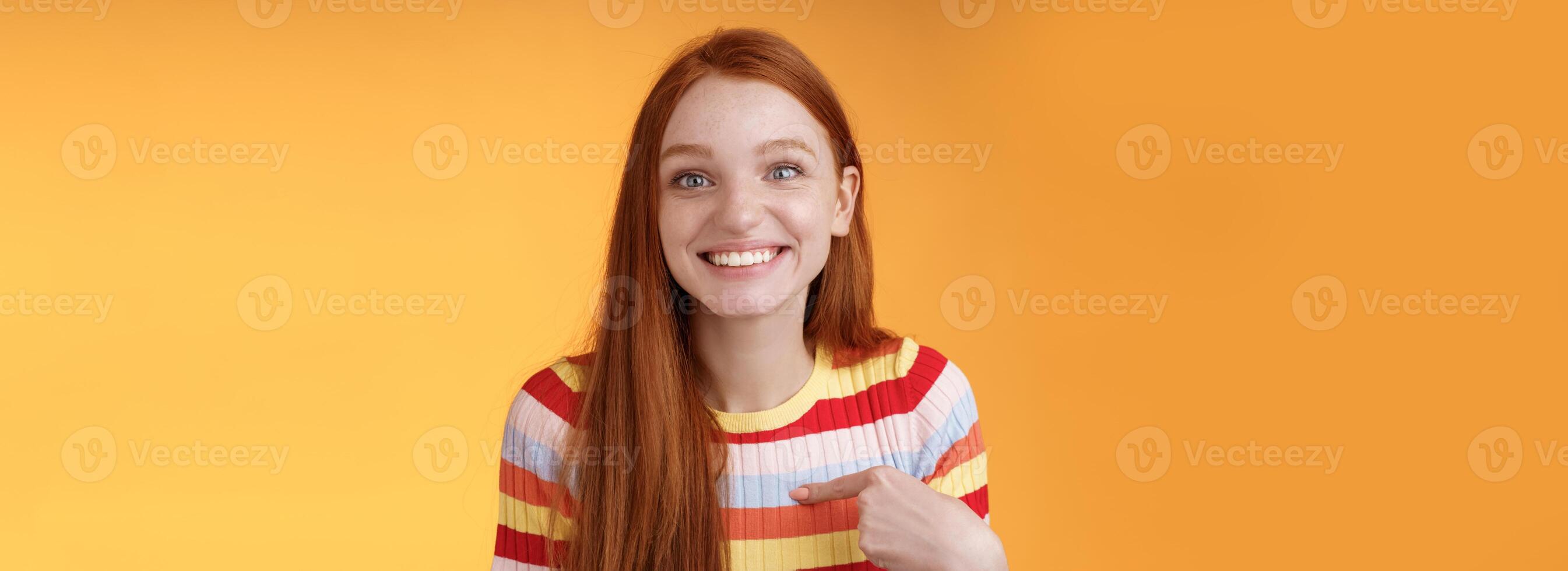 contento eccitato ghignante testa Rossa ragazza scelto sorridente gratitudine Contentissimo volentieri puntamento se stessa Guarda sorpresa grato telecamera avuto lavoro, ricevere Borsa di studio in piedi arancia sfondo foto