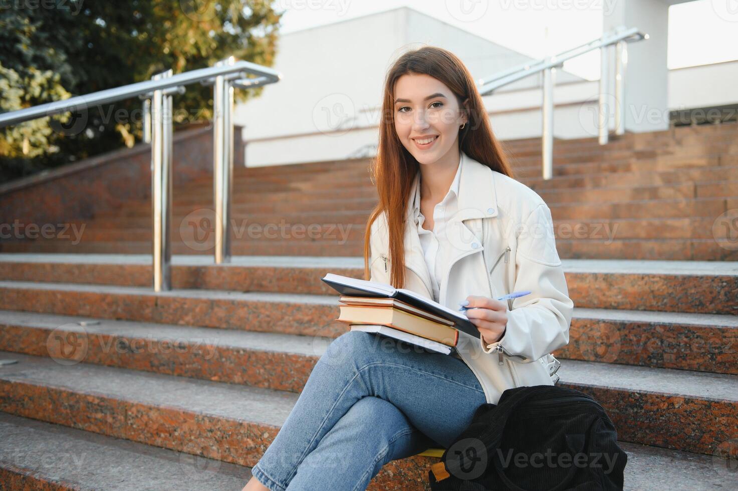 femmina Università alunno con libri all'aperto. sorridente scuola ragazza con libri in piedi a città universitaria. io sono preparato per esame molto bene. ritratto di Perfetto alunno a il Università foto