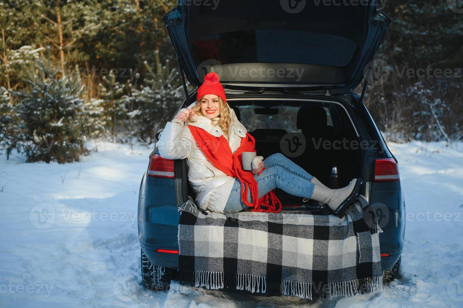 giovane donna seduta nel auto tronco potabile caldo tè e prende un' autoscatto a inverno nevicato giorno. foto