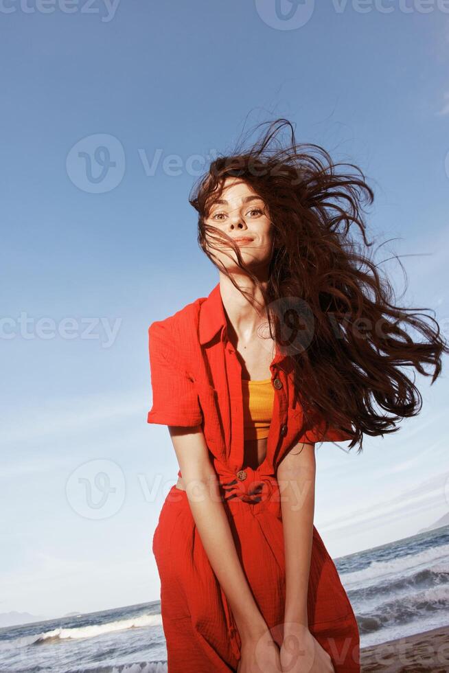 sorridente donna danza con gioia a il soleggiato spiaggia foto