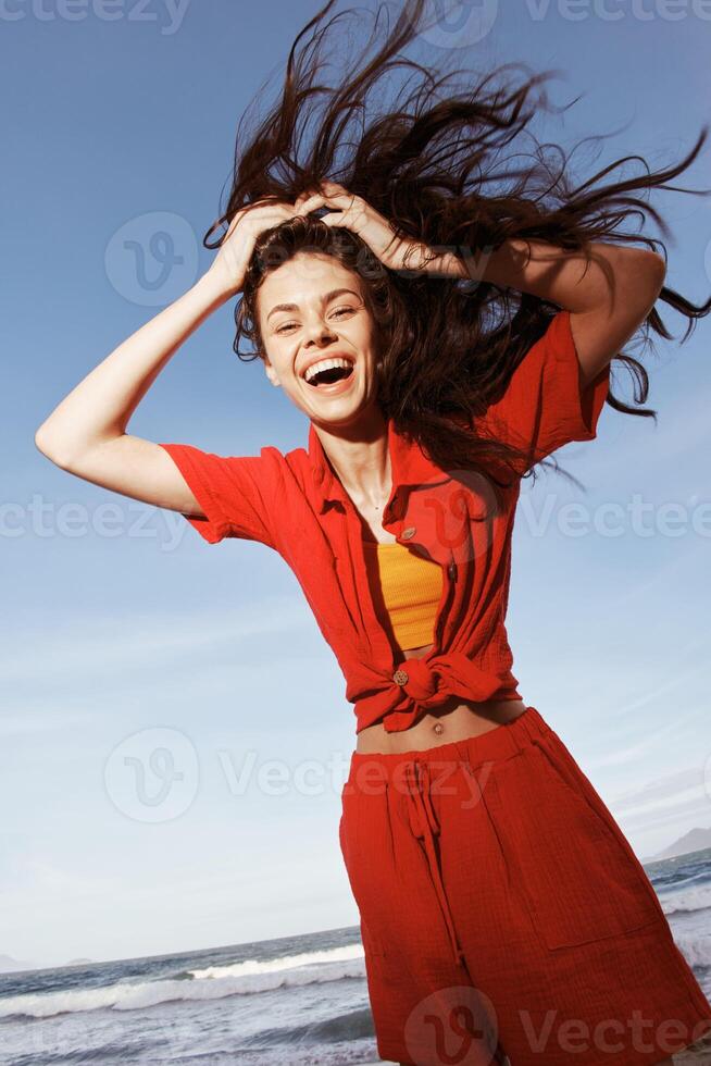 sorridente donna danza con gioia su un' soleggiato spiaggia, Abbracciare una persona la libertà e godendo divertimento estate vacanza foto