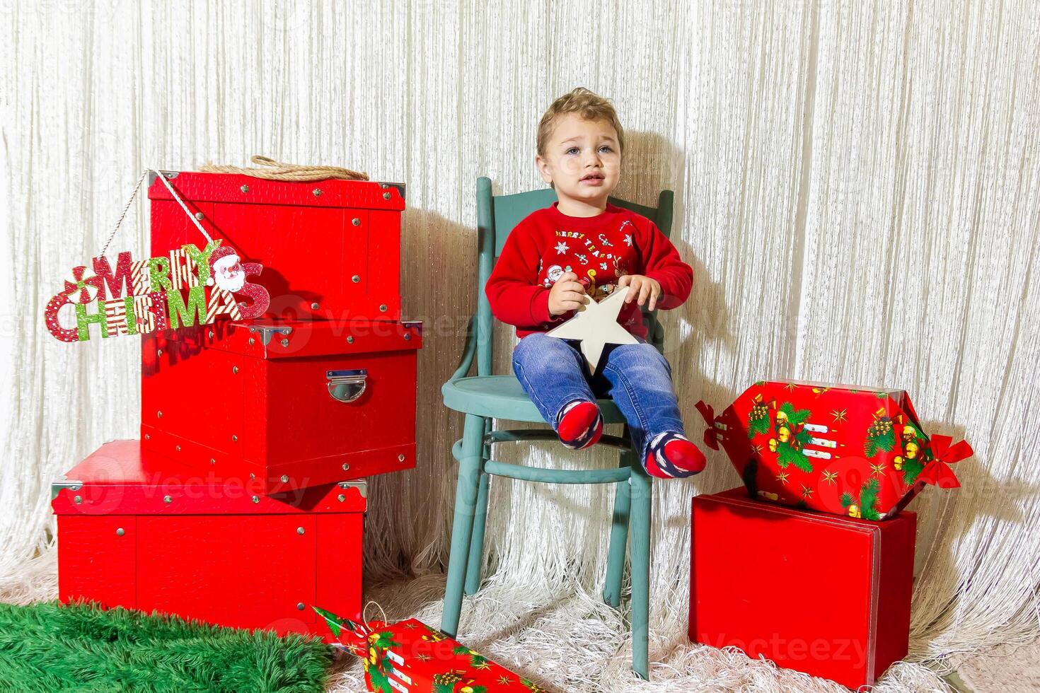 il poco bambino giocando con Natale decorazioni nel studio, poco bambino con Natale palla foto