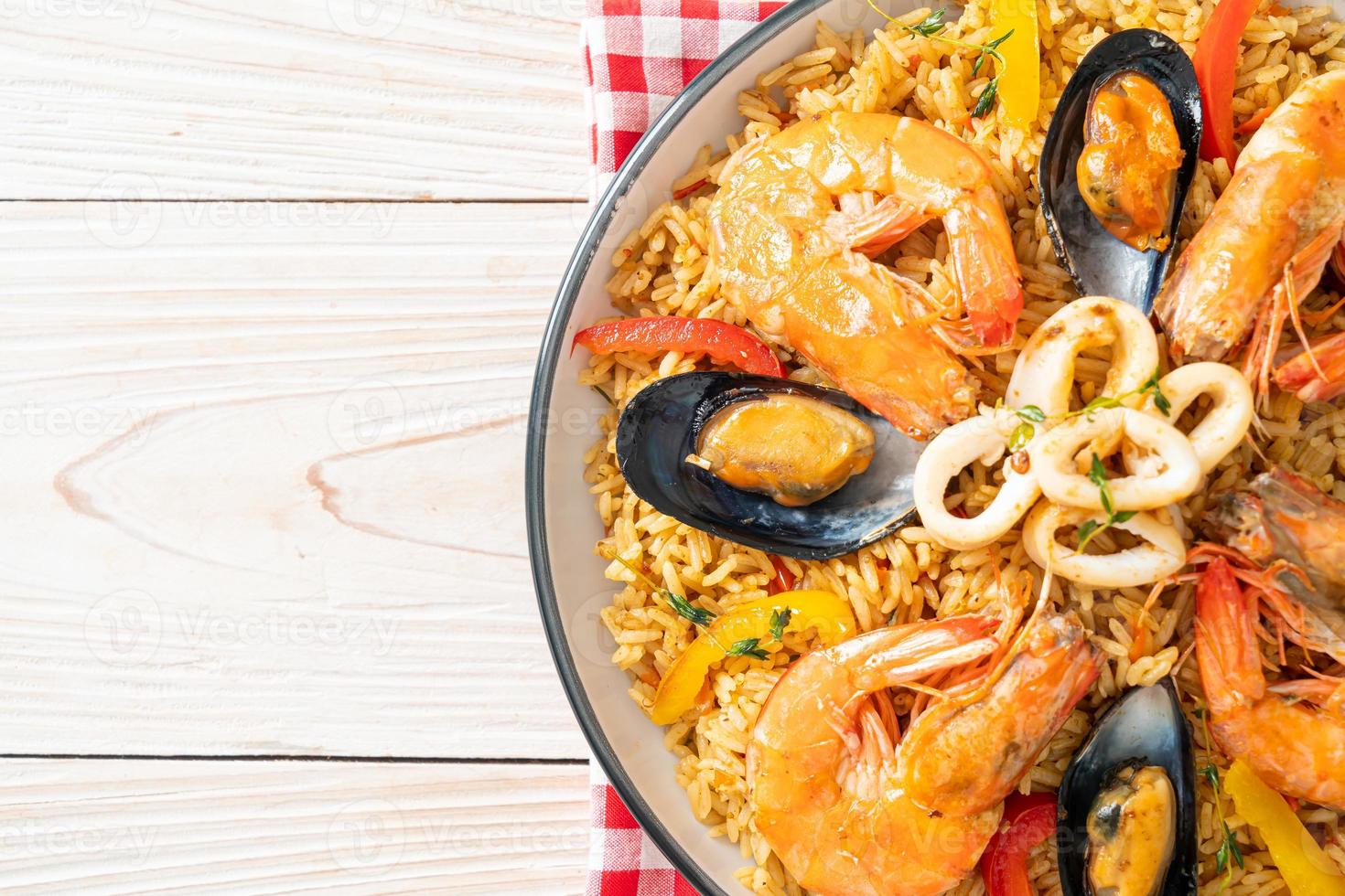 paella di mare con gamberi, vongole, cozze su riso allo zafferano foto