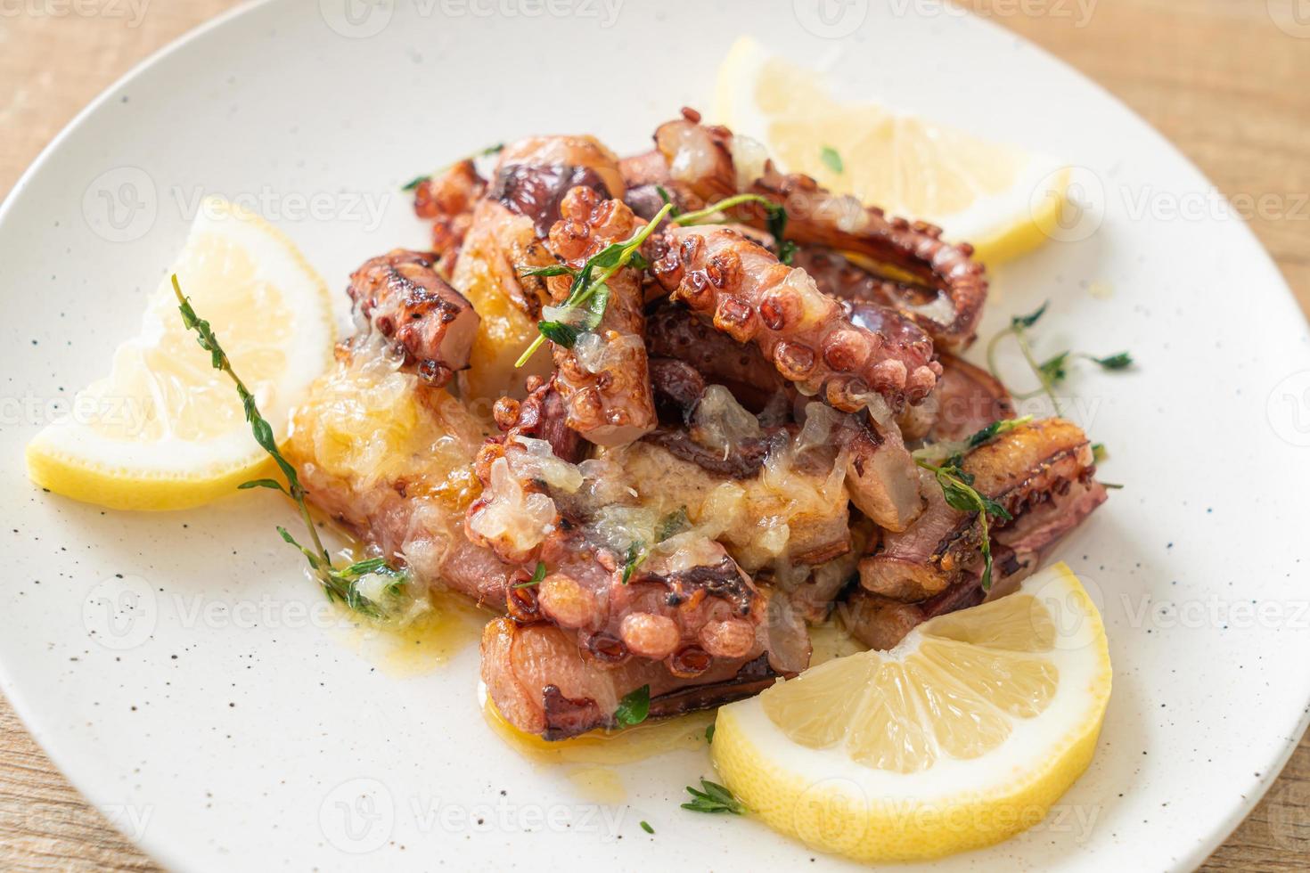 polpo o calamari alla griglia con salsa di burro al limone foto