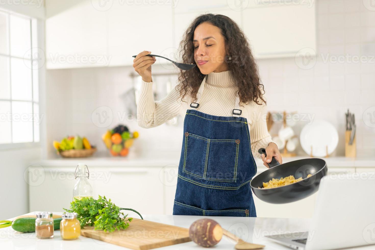 donna latina che gira video e cucina in cucina foto