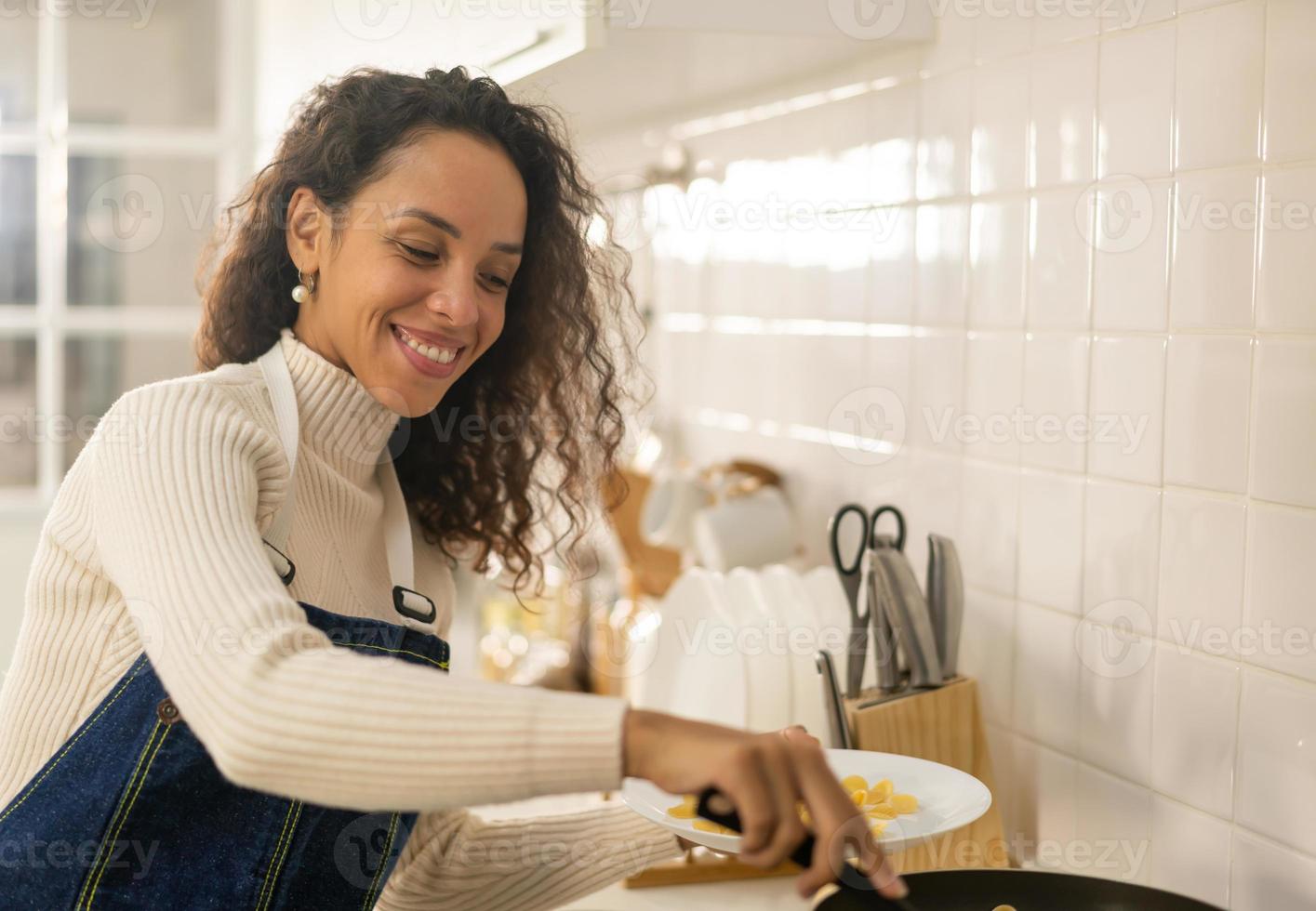 donna latina che cucina in cucina foto