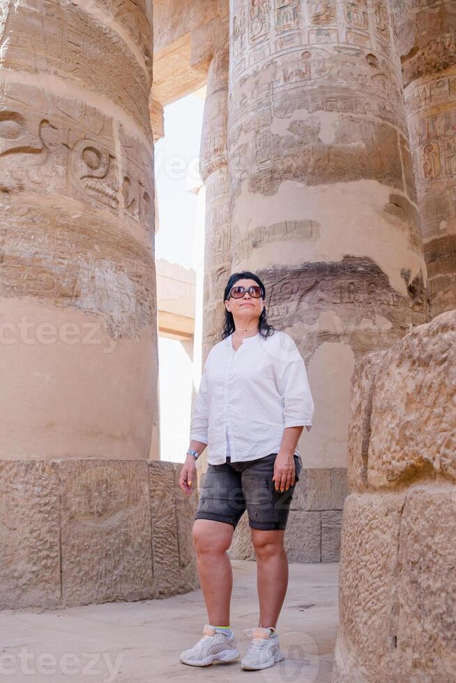 donna viaggiatore esplora il rovine di il antico karnak tempio nel il città di Luxor nel Egitto. foto