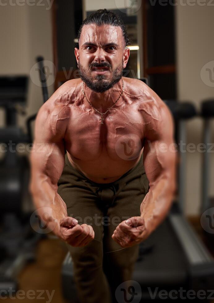 bodybuilder formazione il suo muscoli nel palestra, bodybuilder formazione con manubrio foto