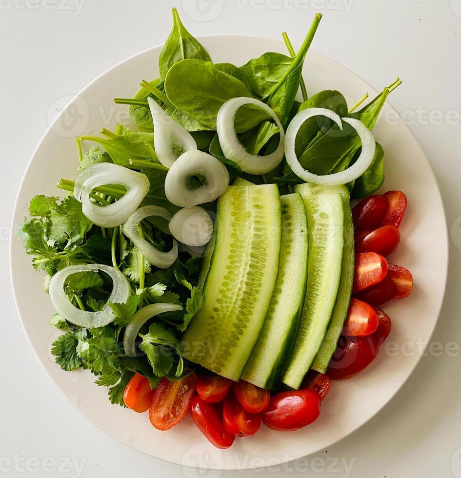 insalata con cetriolo, pomodoro, cipolla e spinaci su bianca sfondo foto