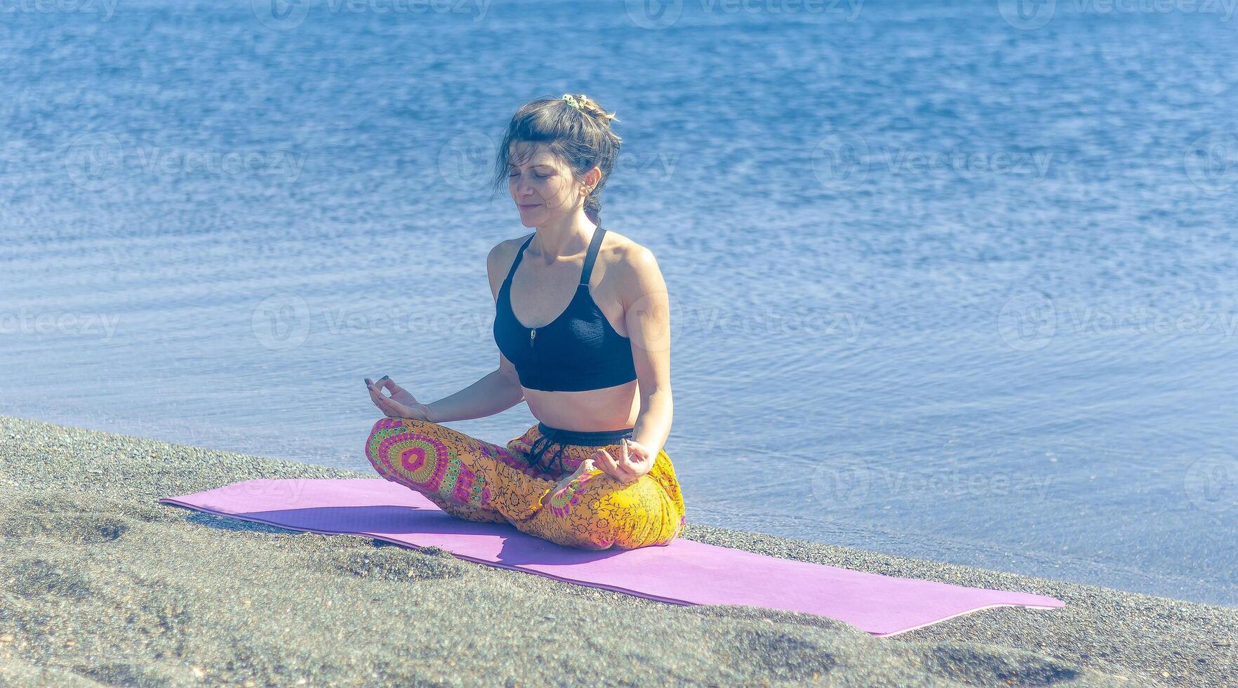 persona fare yoga esercizio su il spiaggia, persona rilassante su il spiaggia, personn fare yoga foto
