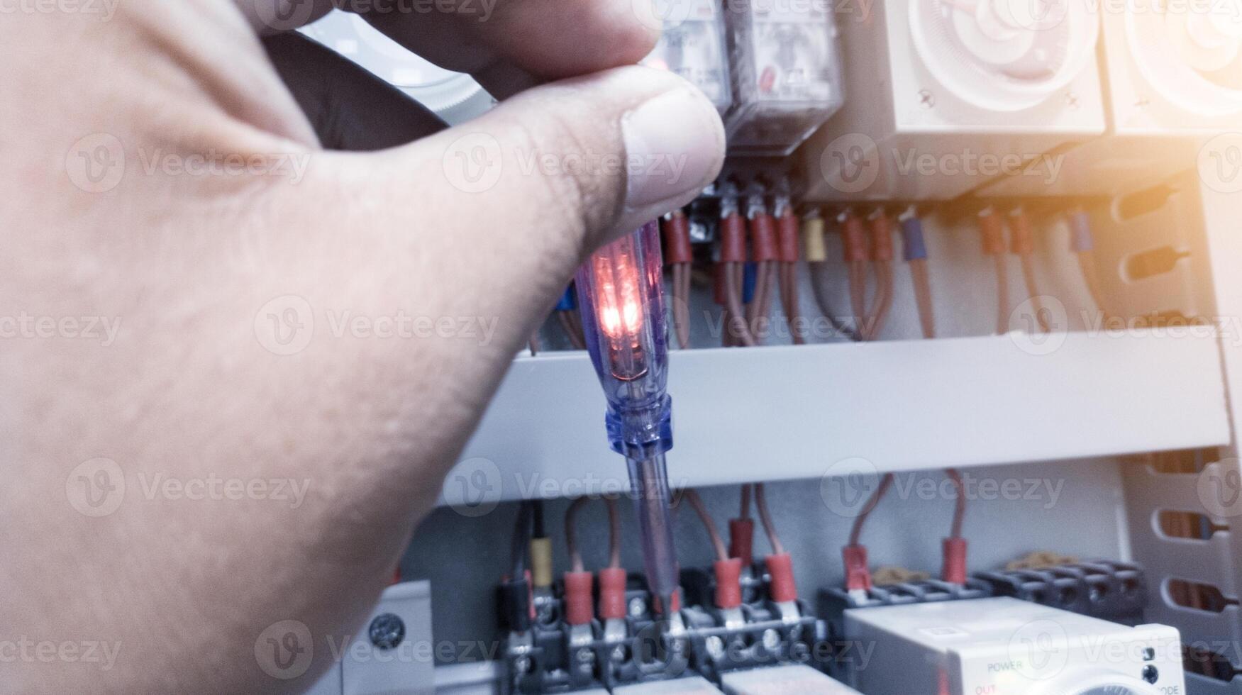 controllo il elettrico energia su il controllo pannello utilizzando un' test penna. foto