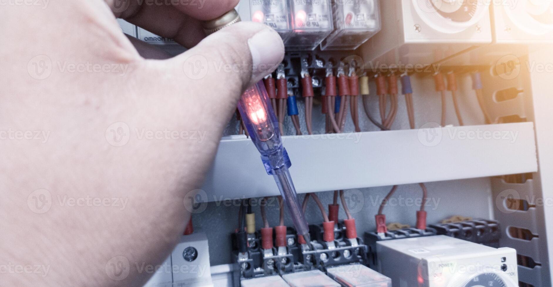 controllo il elettrico energia su il controllo pannello utilizzando un' test penna. foto