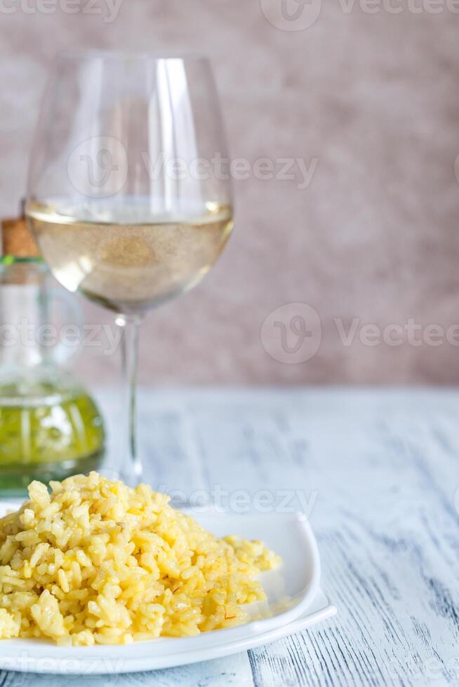 porzione di risotto con bicchiere di bianca vino foto