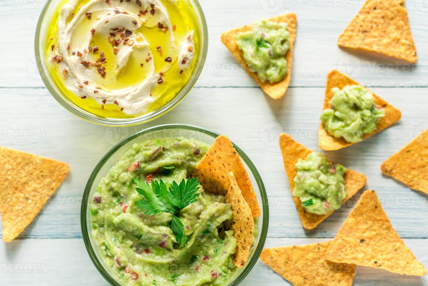 ciotole di hummus e guacamole con tortilla patatine fritte foto