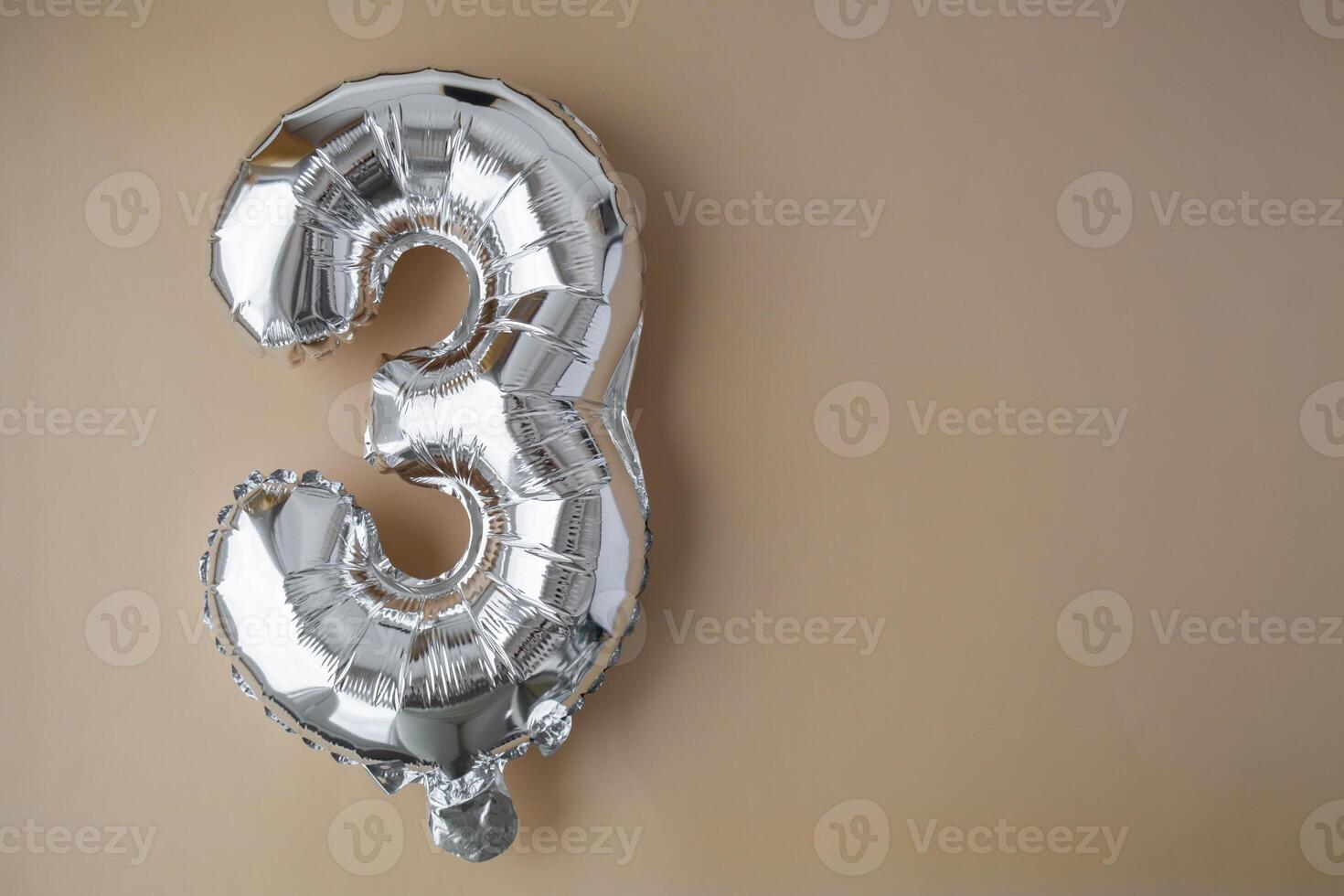 3 tre metallico Palloncino su beige neutro sfondo. saluto carta argento Foglio Palloncino numero contento compleanno vacanza concetto. copia spazio per testo. celebrazione festa congratulazione decorazione foto