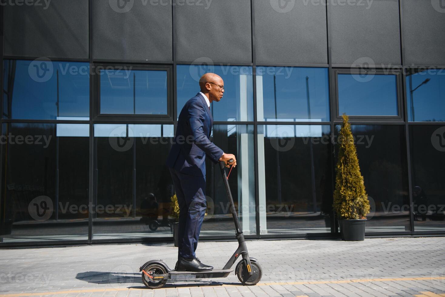 giovane africano uomo d'affari equitazione un elettrico scooter foto