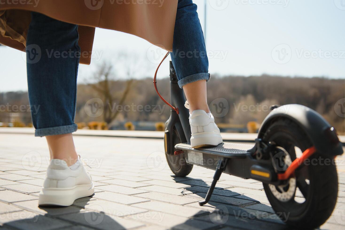 ritagliata su donna gambe piedi equitazione su elettrico calcio scooter nel città foto