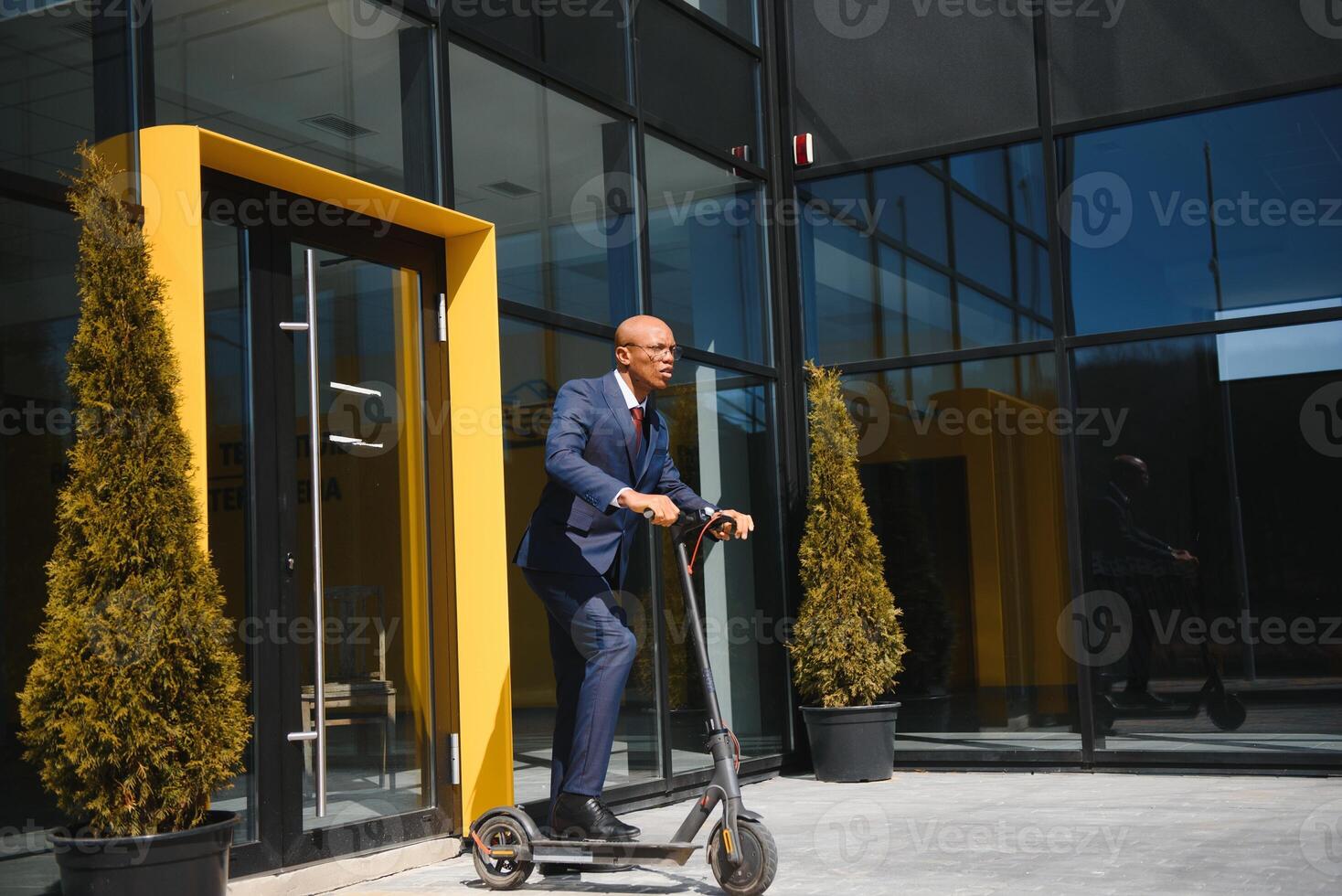 giovane africano uomo d'affari equitazione un elettrico scooter foto