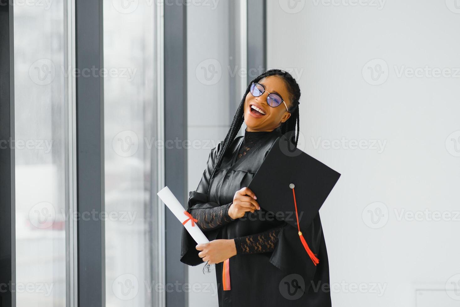 studente laureato afroamericano allegro con il diploma in sua mano foto