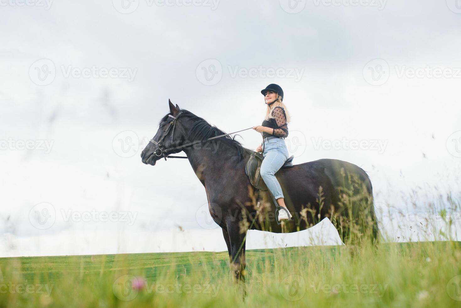 giovane donna equitazione un' cavallo su il verde campo foto