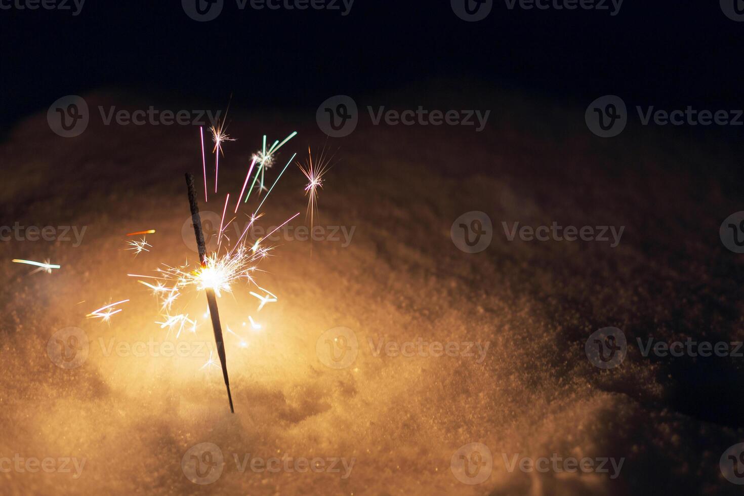 festivo sparklers bruciare su il neve a notte. nuovo anno e Natale carta foto