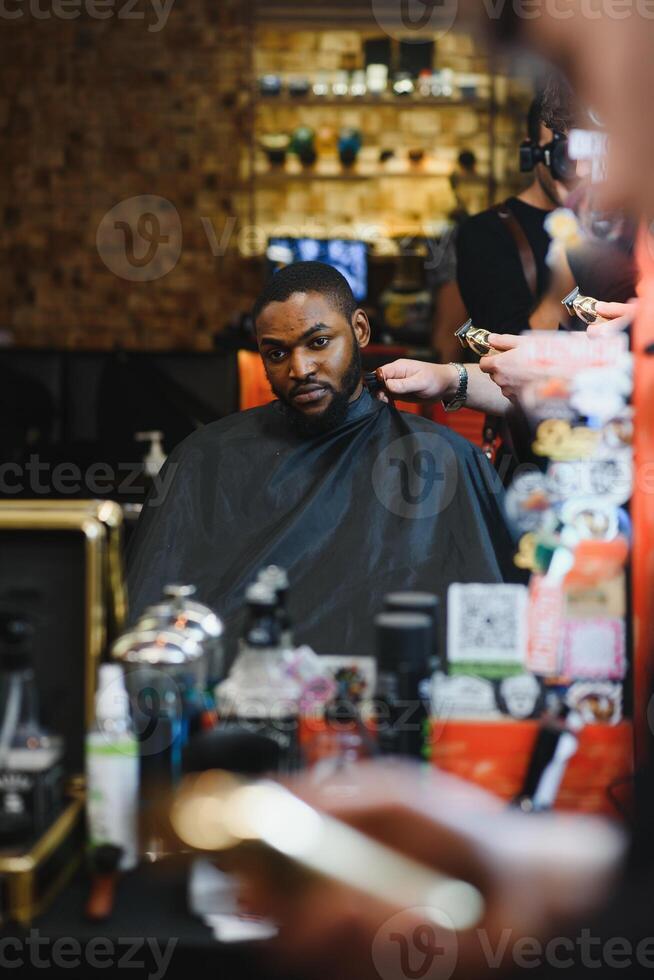 nero uomo nel il barbiere. carino nero uomo fa un' taglio di capelli nel il africano salone. capelli stile. taglio di capelli per adulti. foto