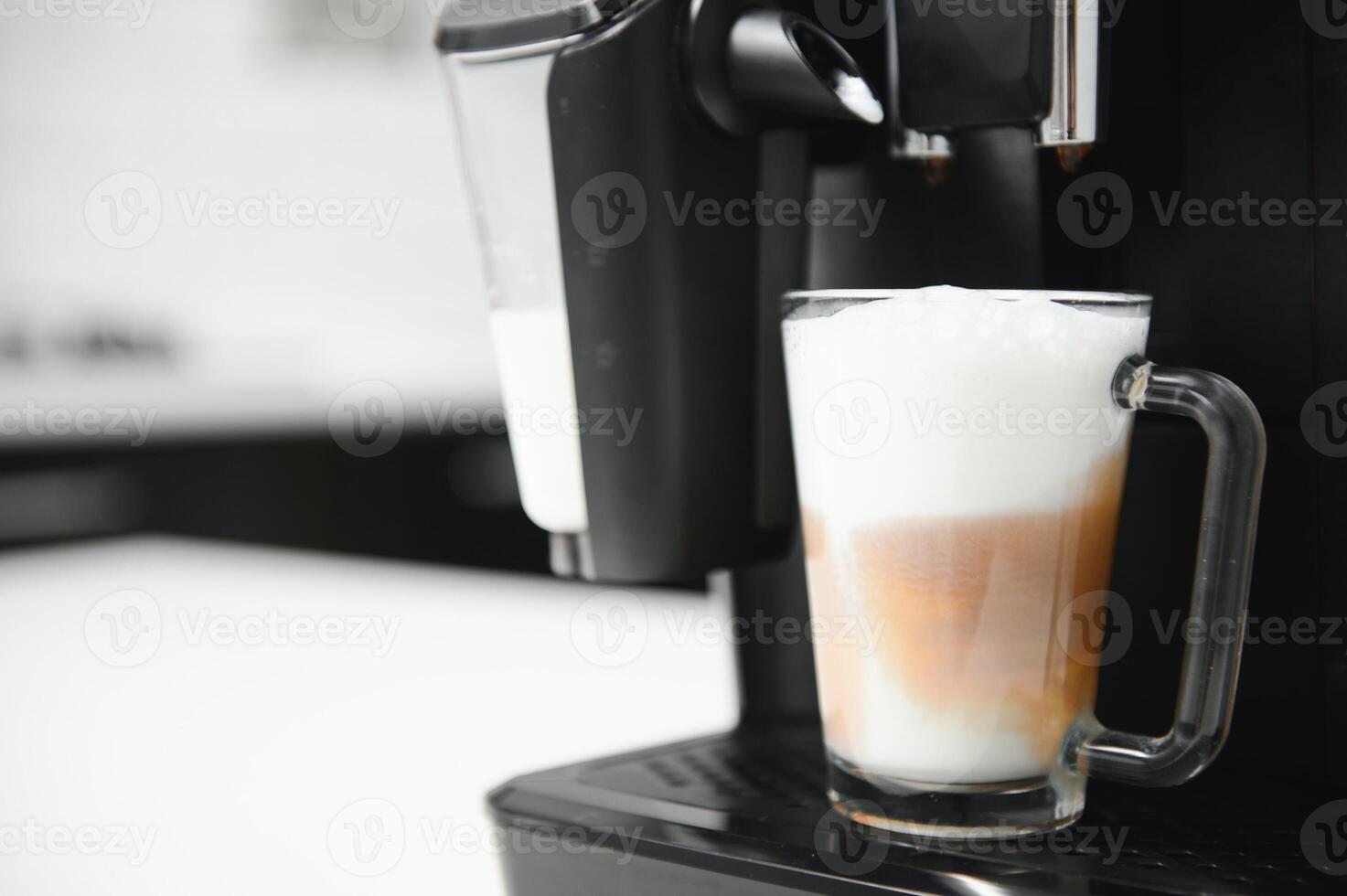 moderno caffè macchina con bicchiere tazza di latte macchiato su bianca marmo controsoffitto nel cucina foto