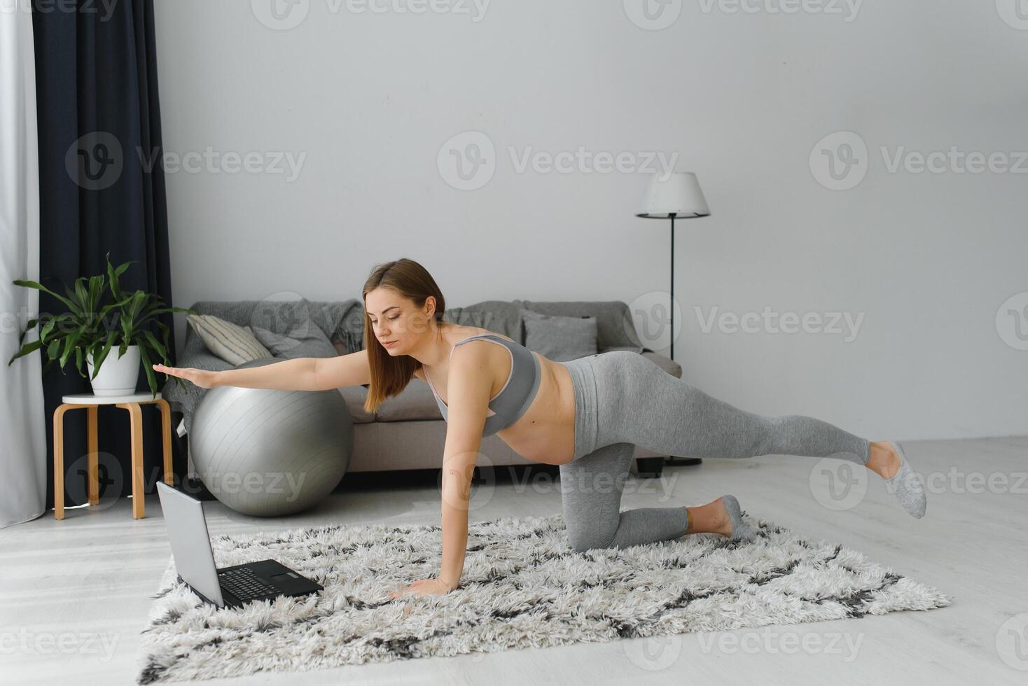 salutare gravidanza yoga e fitness concetto. giovane incinta yoga donna Lavorando su nel vivente camera interno. incinta modello fare prenatale sedia posa, utkatasana yoga posa foto