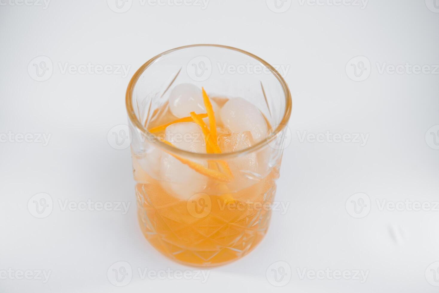 bicchiere di viale cocktail con grande ghiaccio cubo e arancia scorza, classico cocktail alcolizzato viale con arancia e vermut isolato su bianca sfondo foto