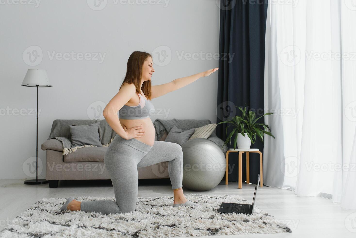 bellissimo giovane incinta donna con il computer portatile formazione a casa foto