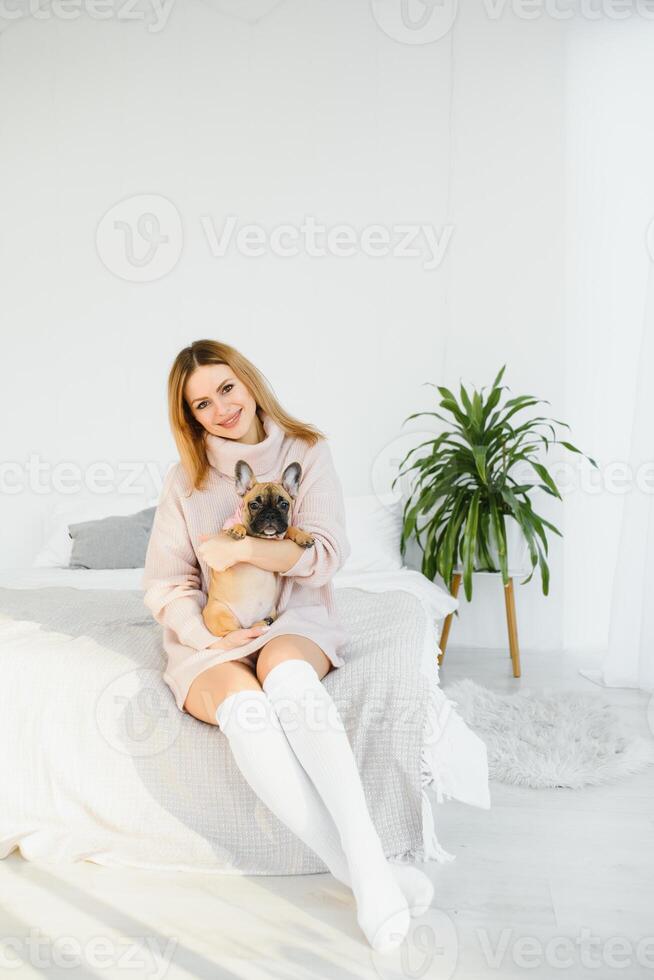 bellissimo giovane bionda donna giocando con sua cane a casa, sorridente. felicità. foto