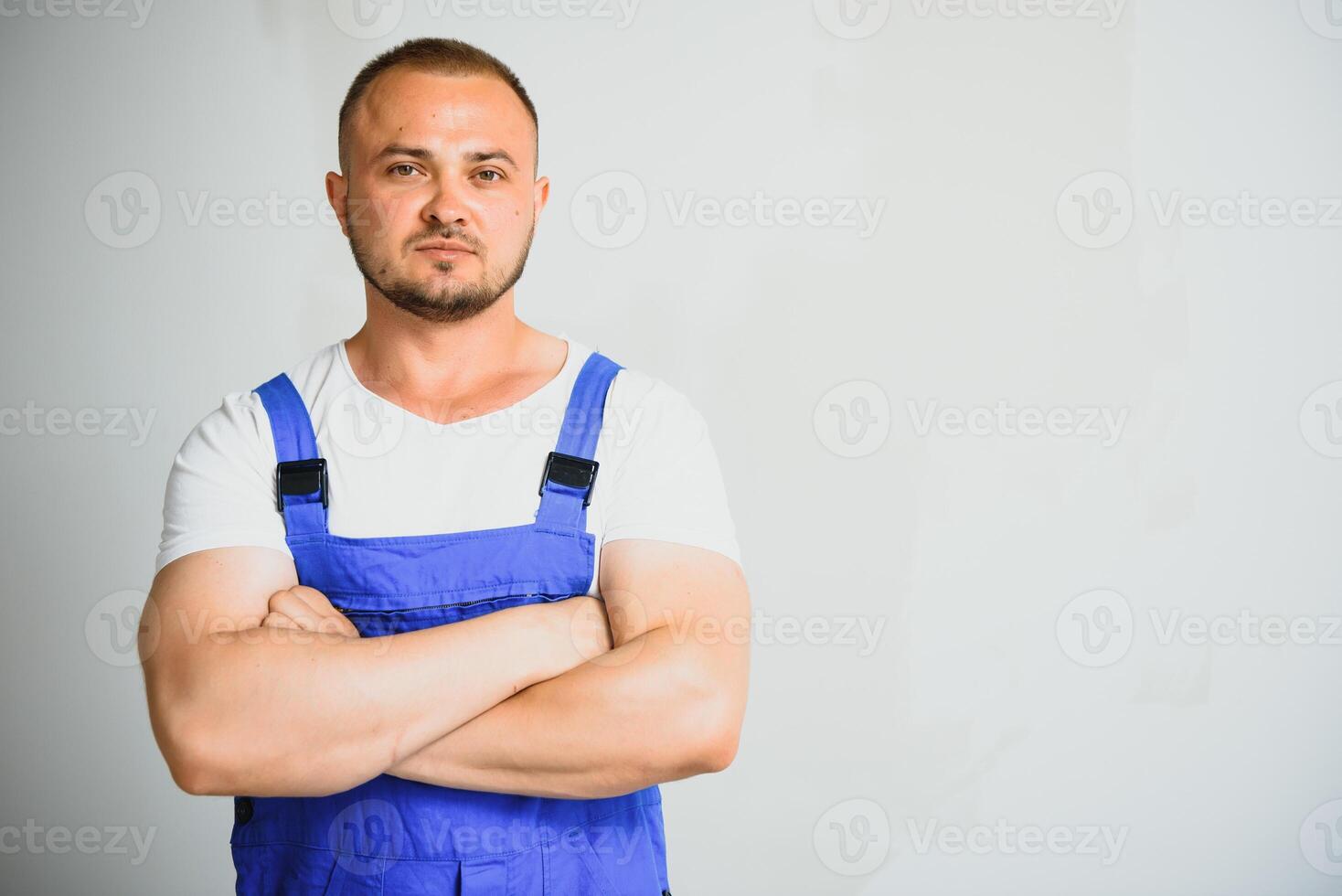 ritratto di giovane tuttofare in piedi su bianca sfondo con copia spazio. riparatore indossare abbigliamento da lavoro uniforme. foto