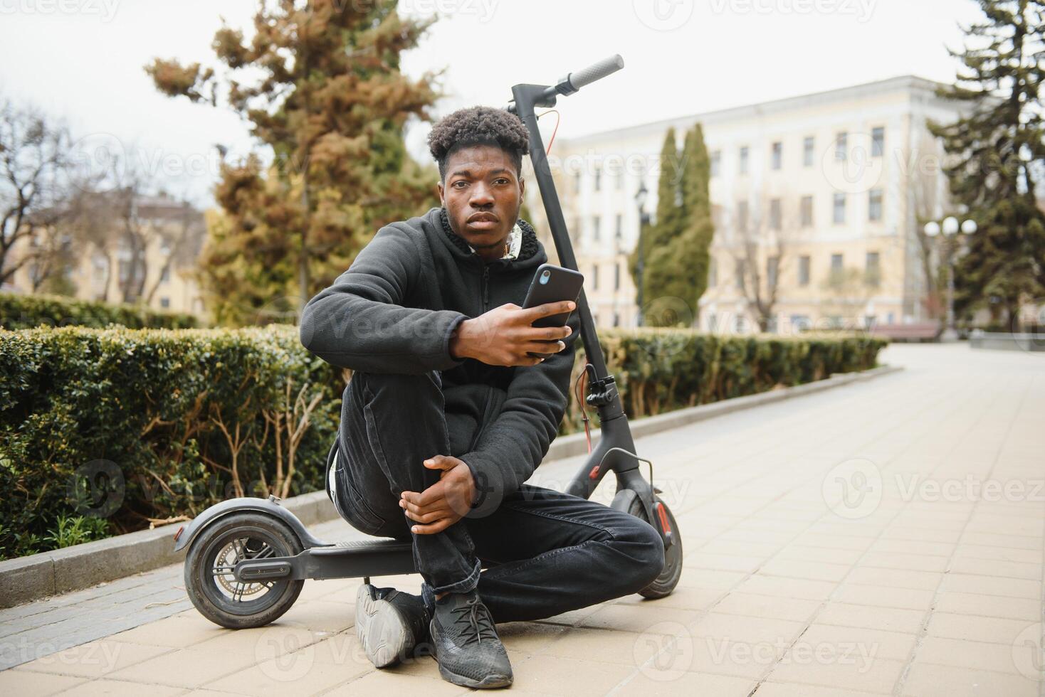 giovane africano americano tipo con elettrico scooter nel il città. il concetto di ecologico trasporto. foto