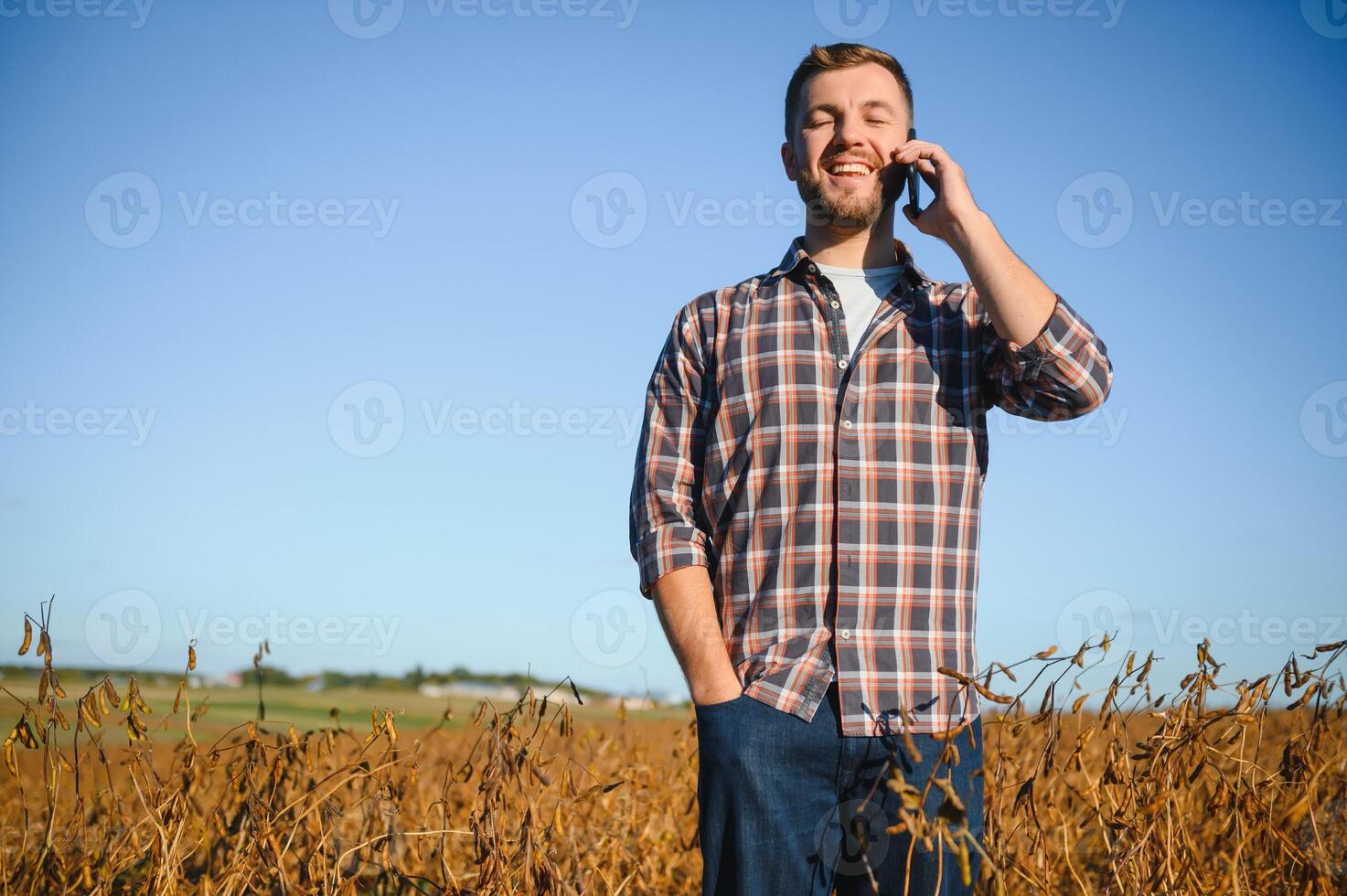 agronomo ispezionando soia fagiolo colture in crescita nel il azienda agricola campo. agricoltura produzione concetto. giovane agronomo esamina soia Ritaglia su campo nel estate. contadino su soia campo foto