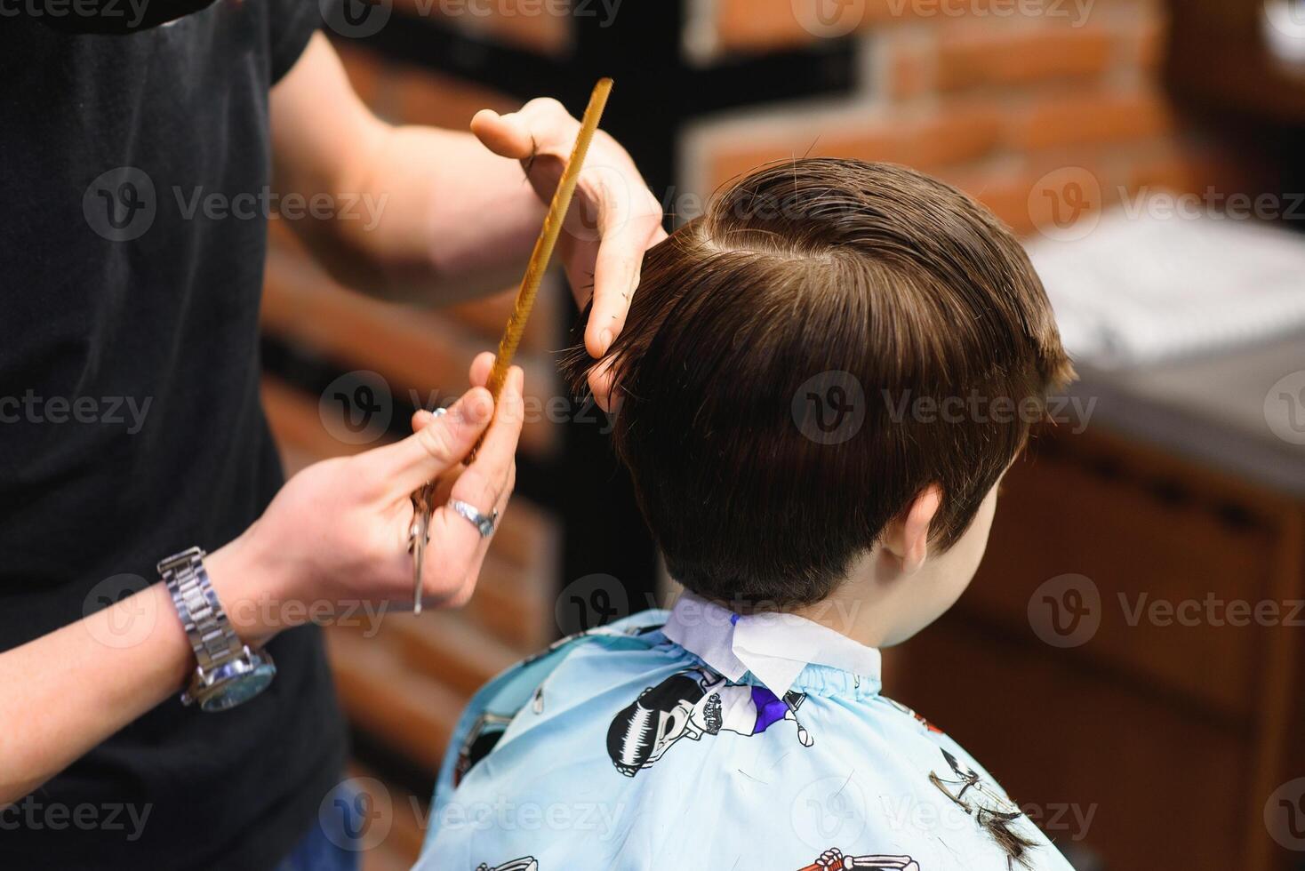 un' poco carino ragazzo si siede nel un' parrucchiere a il dello stilista, un' scolaro è ottenere capelli tagliare nel un' bellezza salone, un' bambino a un' dal barbiere, un' corto Uomini taglio di capelli foto