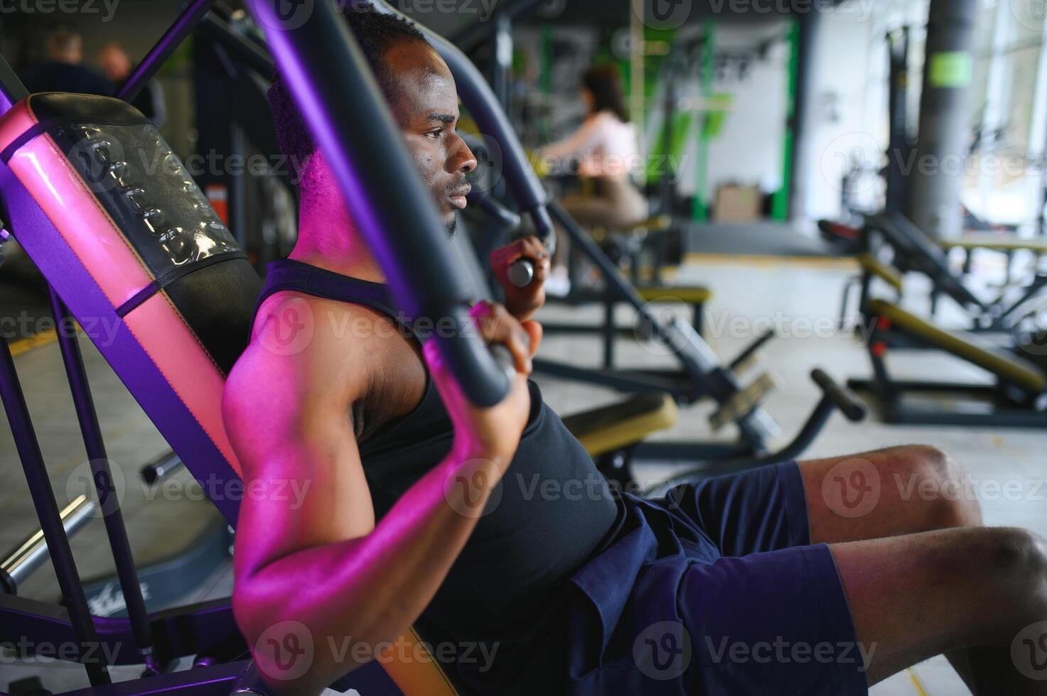 motivata giovane nero sportivo avendo allenarsi su canottaggio macchina foto