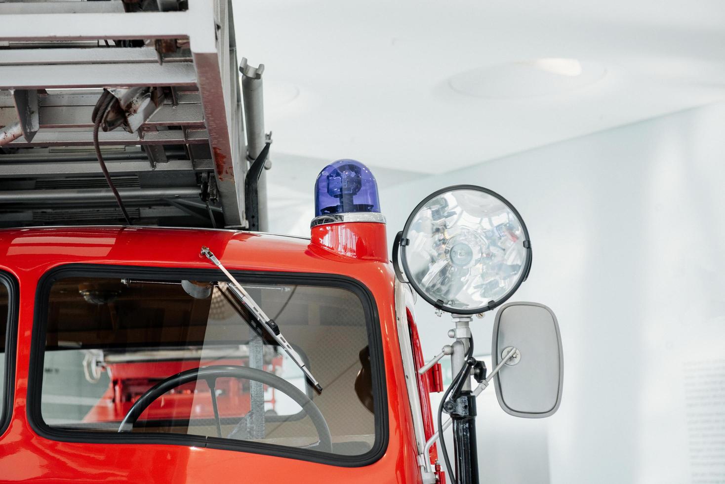 foto ravvicinata dei fari. davanti al camion dei pompieri rosso lucido in piedi al coperto alla mostra