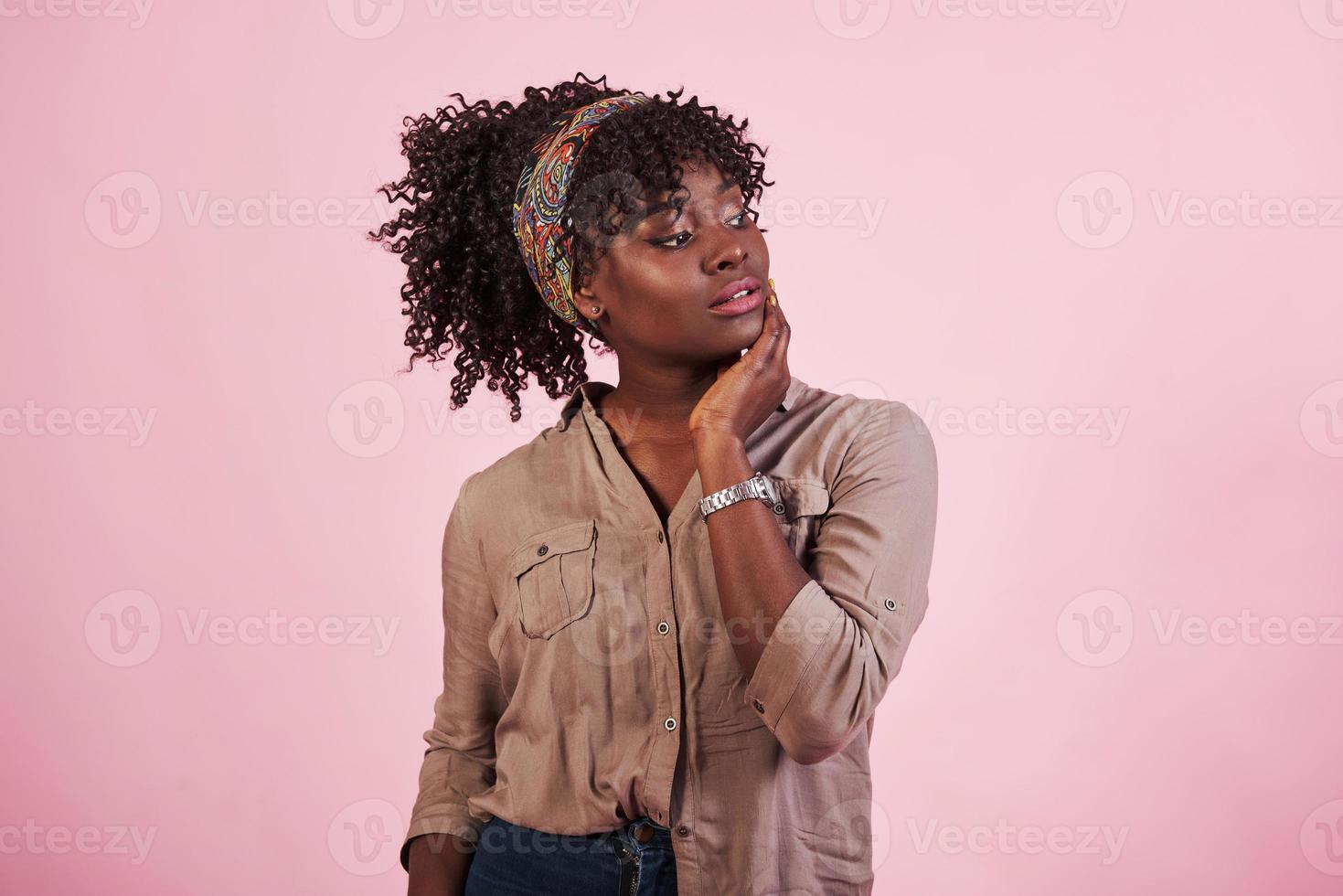 ritratto di attraente ragazza afroamericana in abbigliamento casual e guarda a portata di mano in posa per la telecamera foto