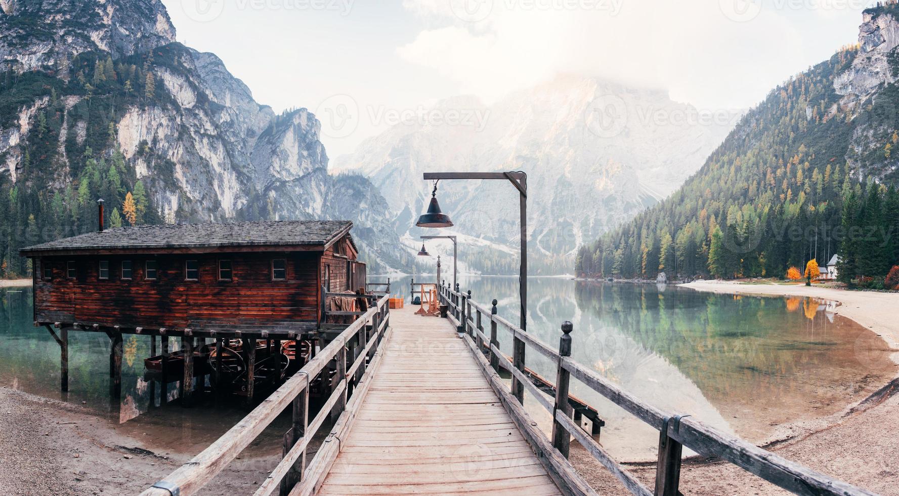 andando in acqua. buon paesaggio con montagne. luogo turistico con edificio in legno e pera foto