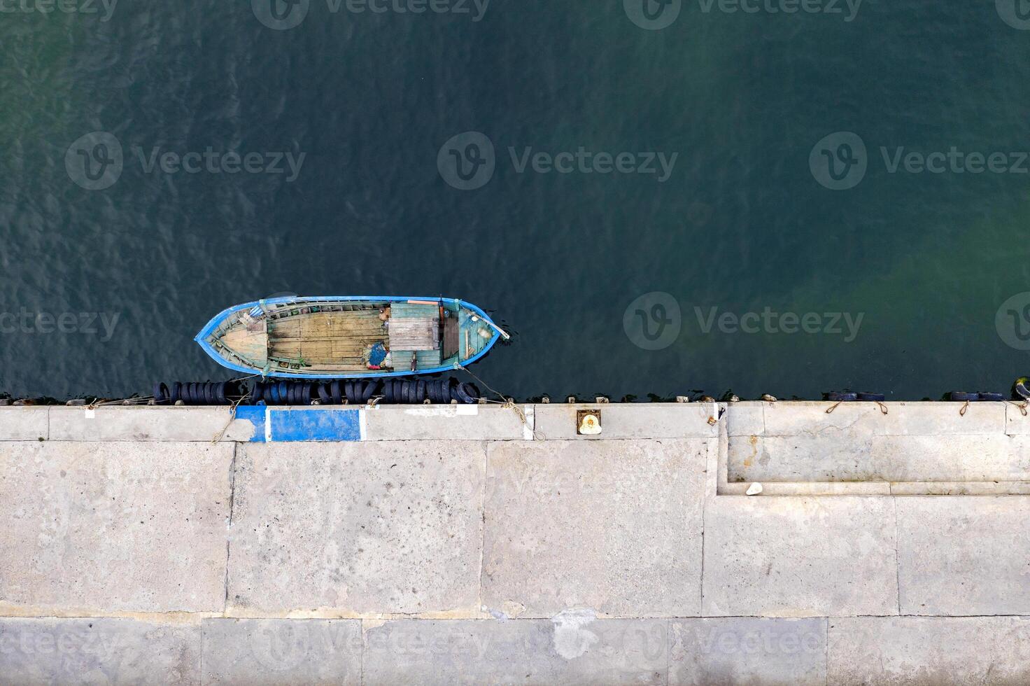 aereo superiore Visualizza di fuco di il ormeggiato piccolo pesca barca a il banchina. foto