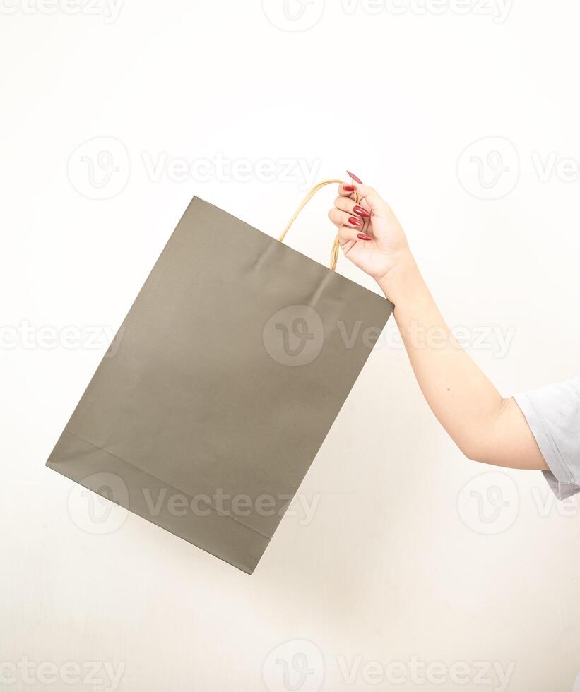 mano Tenere un' shopping carta Borsa contro un' bianca isolato sfondo foto