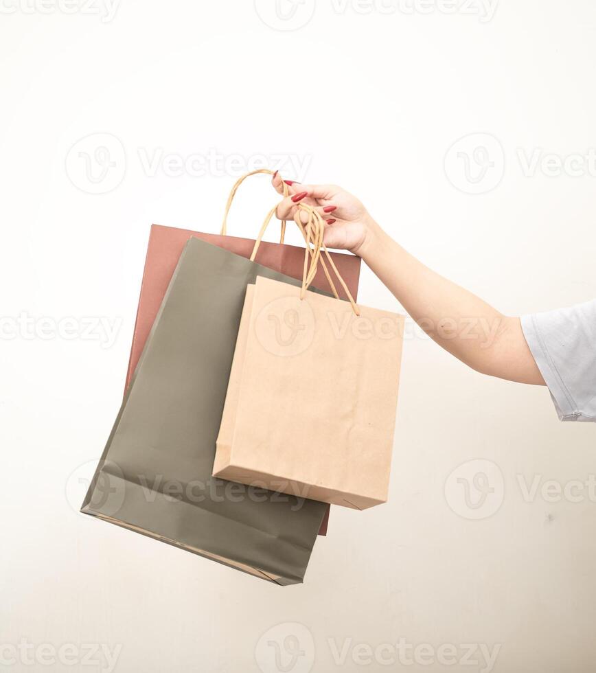 mano Tenere un' shopping carta Borsa contro un' bianca isolato sfondo foto