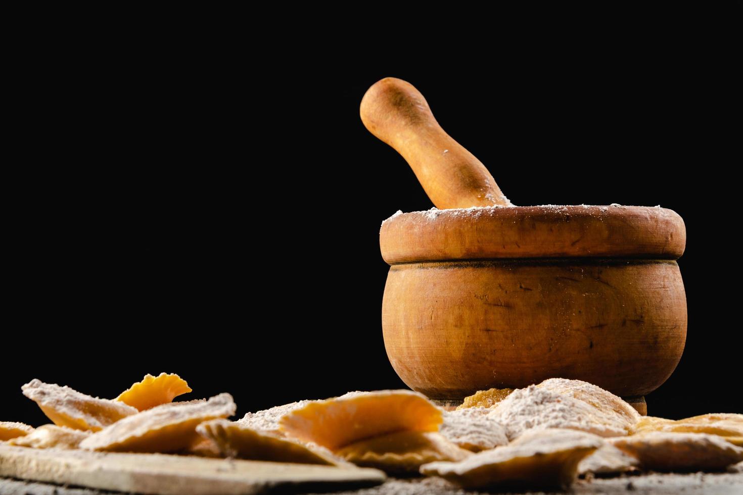 gustosi ravioli crudi con farina e basilico su tavola di legno foto