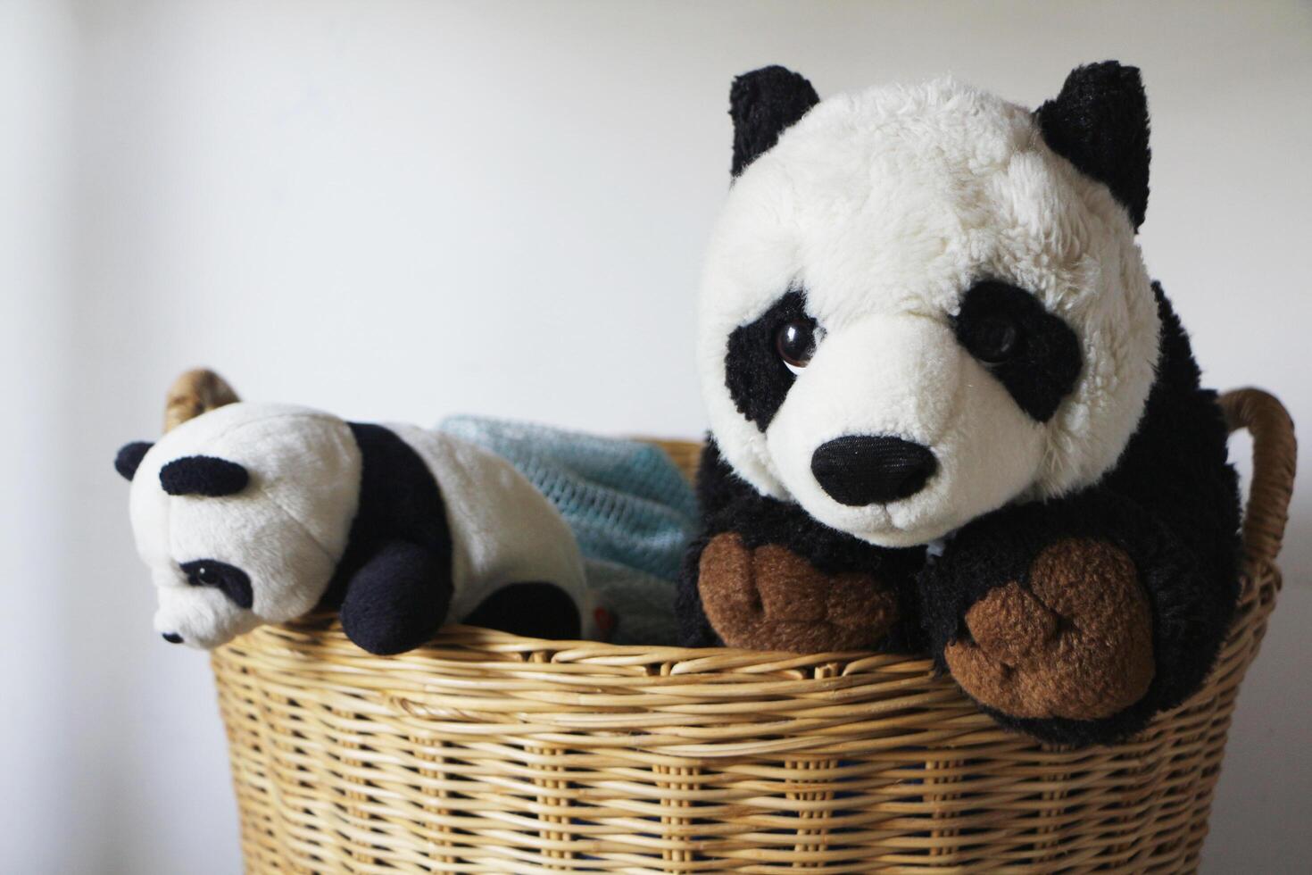 panda Bambola nero e bianca nel di vimini cestino per lavanderia preparazione. foto