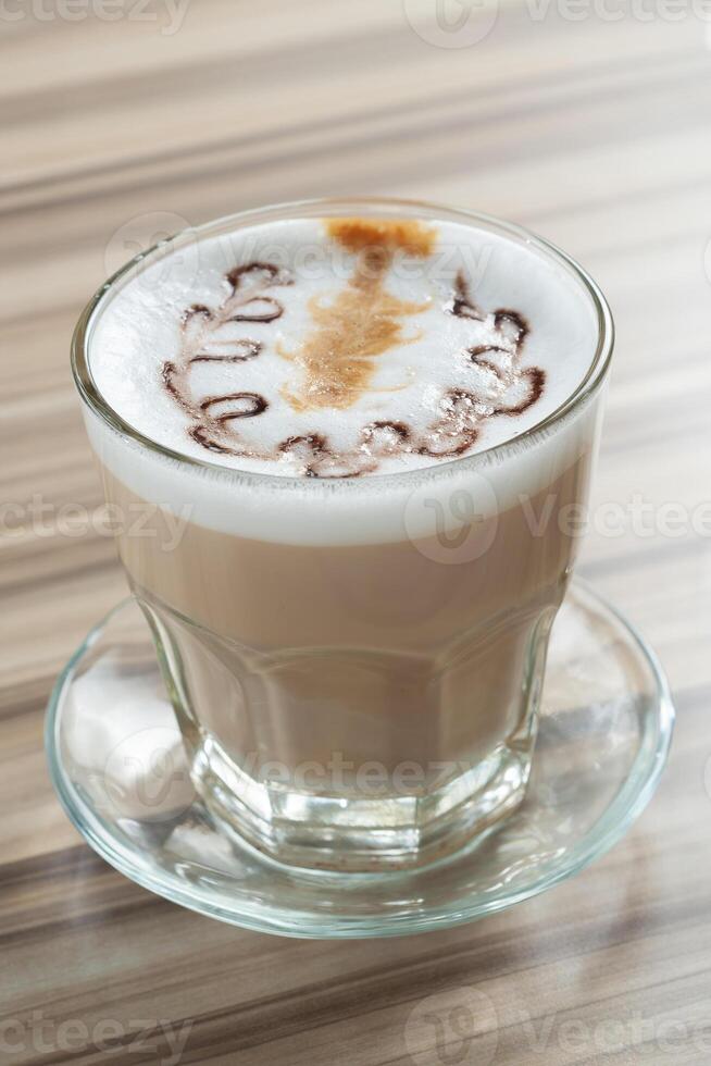vicino su bicchiere di caffè con fiore forma latte macchiato arte foto
