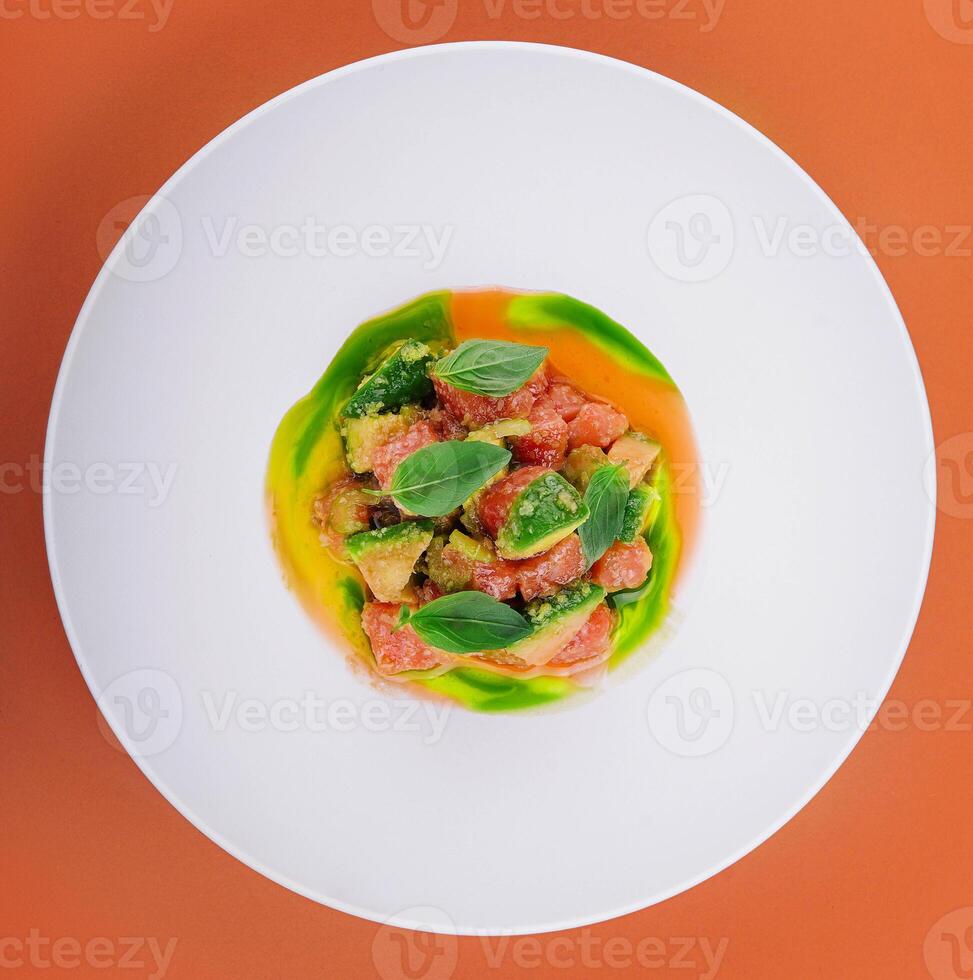 salmone con avocado e basilico su bianca piatto foto