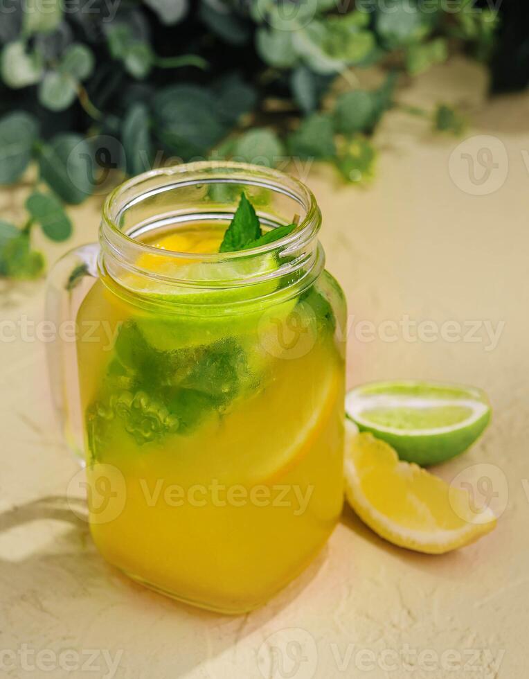limonata con fresco arancia, lime e menta nel bicchiere brocca foto